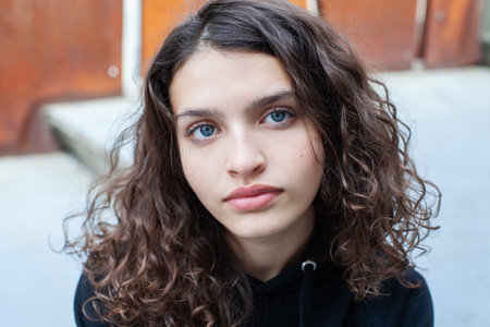 Portrait of a beautiful young girl with blue eyes and curly hairの写真素材