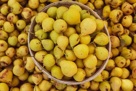 Yellow pears in a basket on the counter of a farmers marketの写真素材