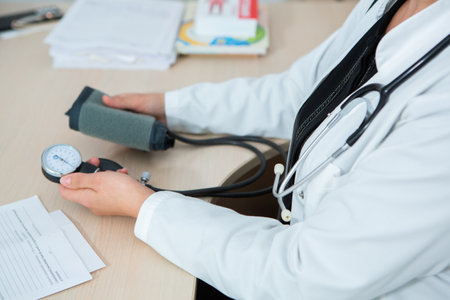 Close-up of doctor measuring blood pressure with sphygmomanometerの写真素材