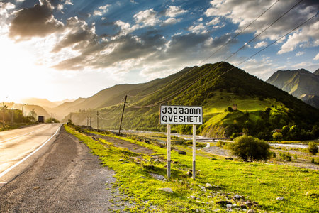 Road in the mountains at sunset. Beautiful nature landscape with road sign