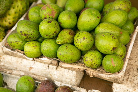 Avocado fruit in a basket for sale at a market stall.