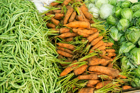 Fresh carrots and beans on the counter of a farmers market in Thailand