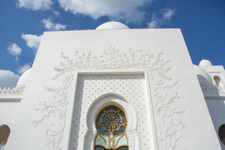 White mosque with blue sky and white clouds in Dubai, United Arab Emiratesの写真素材
