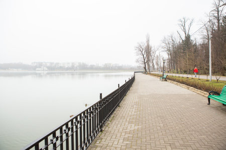 Lakeside promenade on a foggy day in early springの写真素材