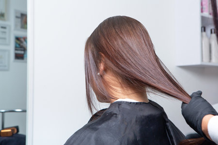 Professional hairdresser cutting hair of young woman in beauty salonの写真素材