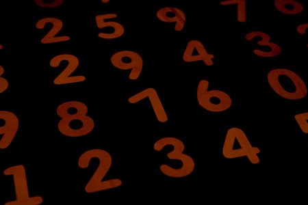 Orange numbers on a black background. Abstract background of numbers. Numbers from zero to nine.