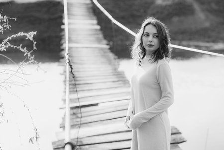 Black and white portrait of young beautiful woman on the wooden bridge.の写真素材