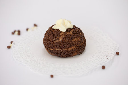 Chocolate muffin with butter cream on a white napkin.の写真素材
