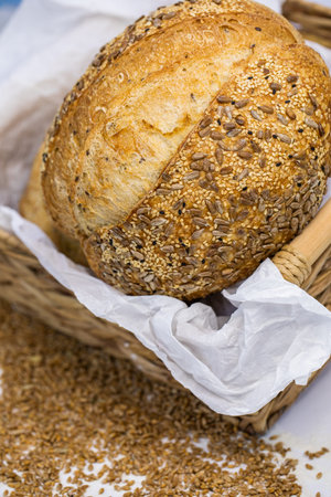 Bread with sesame seeds in a basket on a wooden background.の写真素材