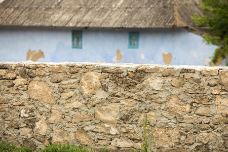 Old stone wall and blue house in the countryside. Beautiful nature landscape from the Republic of Moldova in summer. Rural village life in Eastern Europeの写真素材