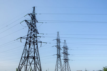 Electricity pylons against the blue sky. Power transmission lines.