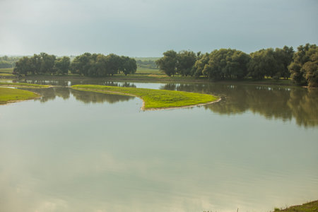 Landscape with a lake and trees in the background on a cloudy day. Beautiful landscape with...