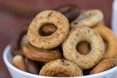 Closeup of a bowl full of bagels on a wooden tableの写真素材