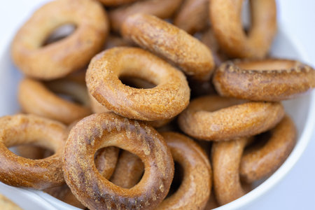 Freshly baked mini bagels on a dark background. Top view. Pretzels in the form of a ring close-up....