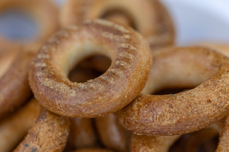 Freshly baked mini bagels on a dark background. Top view. Pretzels in the form of a ring close-up....