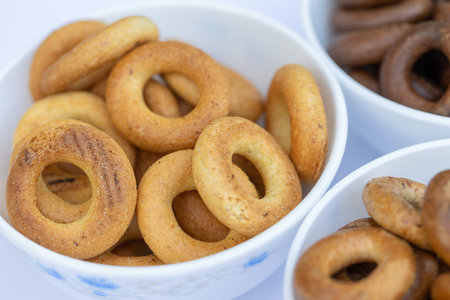 Freshly baked mini bagels on a dark background. Top view. Pretzels in the form of a ring close-up....