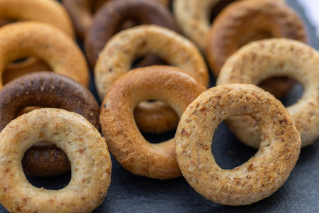 Freshly baked mini bagels on a dark background. Top view. Pretzels in the form of a ring close-up....
