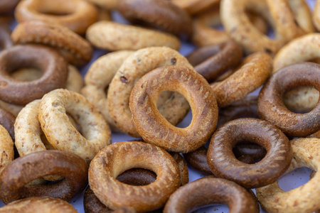 Freshly baked mini bagels on a dark background. Top view. Pretzels in the form of a ring close-up....