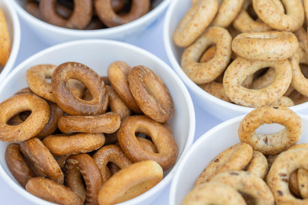 Close up of a selection of bagels in a white bowl.