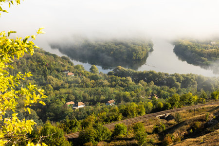 Morning fog over the river, view from the hill to the village