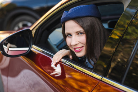 Portrait of a beautiful young woman in a beret sitting in a car