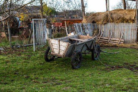 Old wooden cart with hay in the yard of a country house.の写真素材