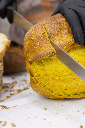 Cutting a loaf of bread with a knife. Selective focus.