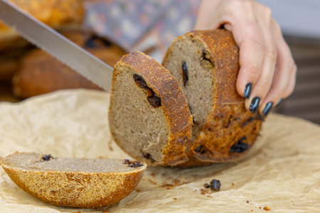 Bread with raisins and a knife in the hands of a woman