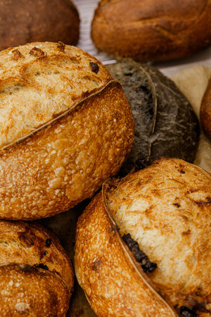 Freshly baked bread with raisins on a wooden background.