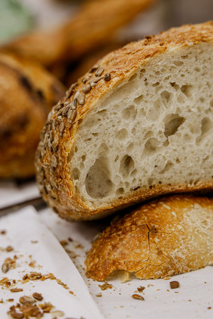 Freshly baked baguette with sunflower seeds on wooden backgroundの写真素材