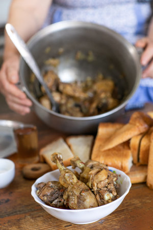 Woman cooking chicken legs in a panの写真素材