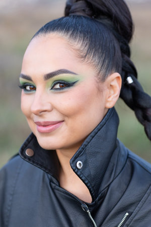 Close up portrait of a beautiful young woman with bright make-up and black leather jacket