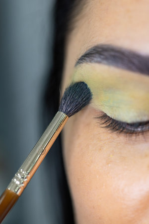 Makeup artist applying make-up on a young woman's faceの写真素材