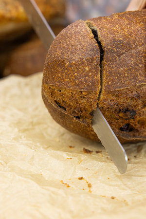 Close up of a freshly baked loaf of bread with a knife.の写真素材