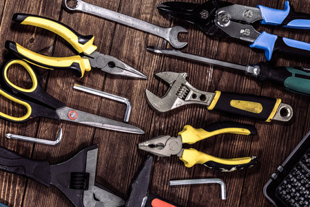 Assorted construction tools on wooden background. Top view with copy space