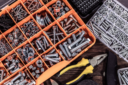 Variety of tools in box on wooden background. Top view.