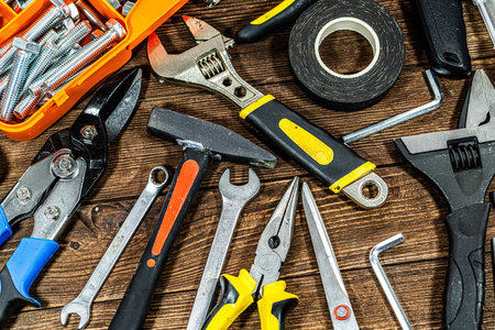Variety of construction tools on wooden background. Top view. Copy space.