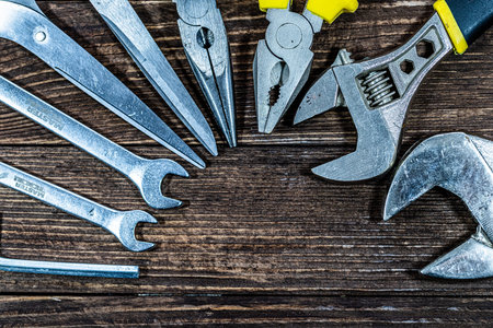 Assorted tools on wooden board. Top view. Copy space.