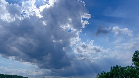 Clouds in the blue sky and sunbeams through the clouds