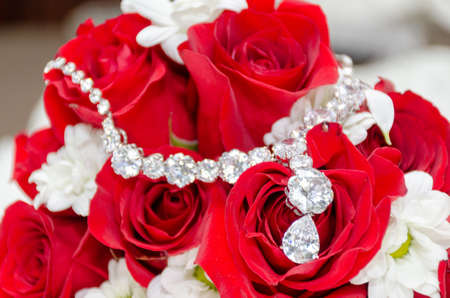 wedding rings on a close up of a red flowerの写真素材