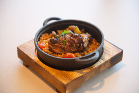 Roast lamb with rice and vegetables in a cast iron pan.の写真素材