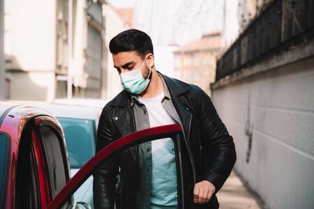 man with protective mask gets out of carの写真素材