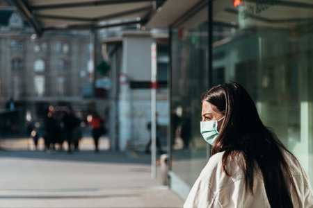 Woman with face mask on the street in the cityの写真素材