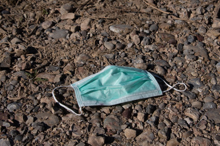 Used face mask lies on the floor and was thrown away - Pollutionの写真素材
