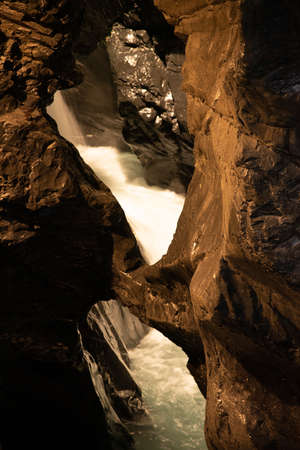 Flowing water of a waterfall inside a mountainの写真素材