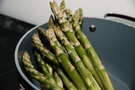 Fresh green seasonal asparagus in a pot ready to cookの写真素材