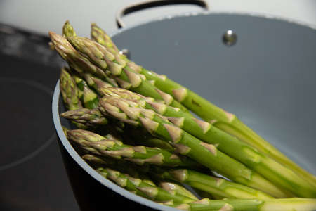 Fresh green seasonal asparagus in a pot ready to cookの写真素材