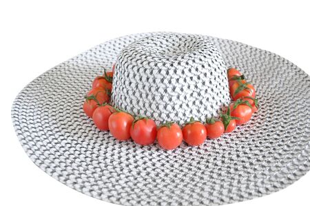 red tomatoes on the woman's hat isolated on whiteの写真素材