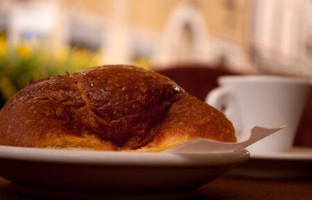 croissant and a cup of coffee in a street cafeの写真素材