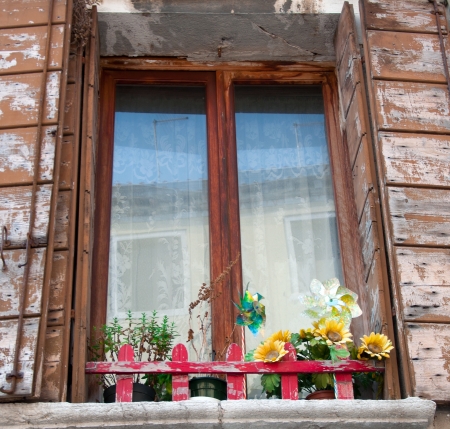old window with shutters and flowers on the windowsillの写真素材